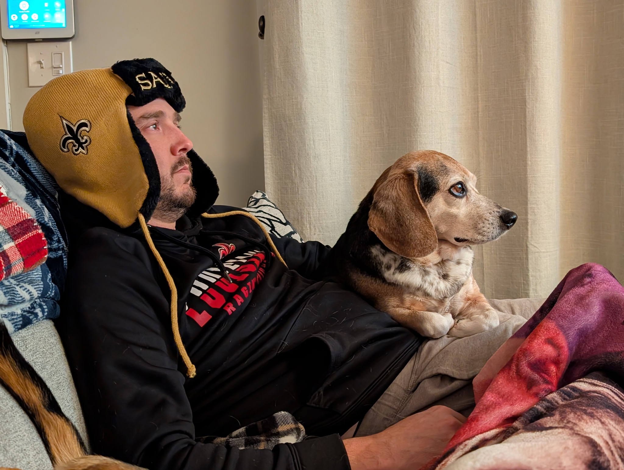 Foster family relaxing on the couch with their foster beagle